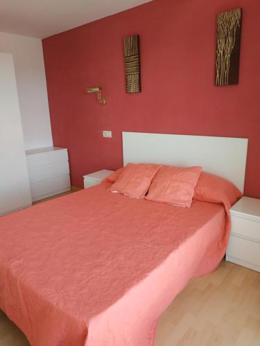 a bedroom with a bed with a red wall at Nores Buenavista 2 in Vilaboa