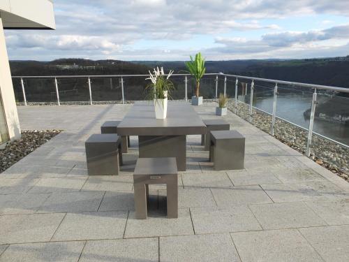 a table and benches on a patio overlooking the water at Kaiser - Ferienwohnungen Dreiburgenblick in Patersberg
