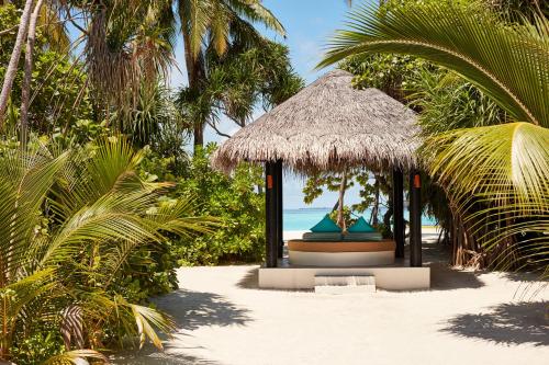 a gazebo on a beach with palm trees at Sun Siyam Iru Fushi with Free Transfer in Manadhoo