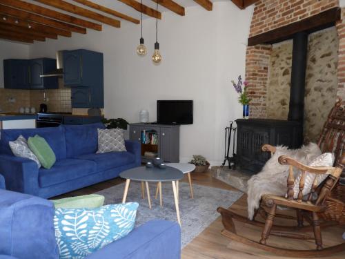 a living room with a blue couch and a dog sitting in a chair at Een prachtige Gîte in Frankrijk Chez Gerard in Vieilleville