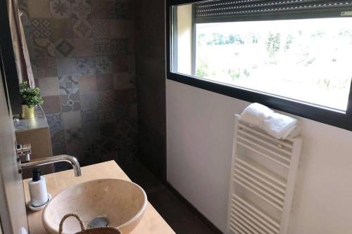 ein Bad mit einem Waschbecken und einem Fenster in der Unterkunft Studio dans les vignes de cassis in Cassis