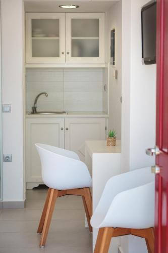 a kitchen with white chairs and a sink at Katerina mare in Naousa
