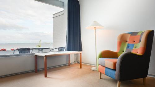 a room with a chair and a table and a window at Hotel Østersø in Aabenraa