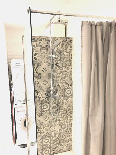 La salle de bains est pourvue d'une douche avec rideau de douche. dans l'établissement Appart 2 chambres gare St Charles, à Marseille