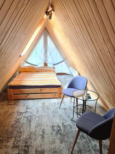 a bedroom with a bed and two chairs and a table at W Zakopanem Hej in Zakopane