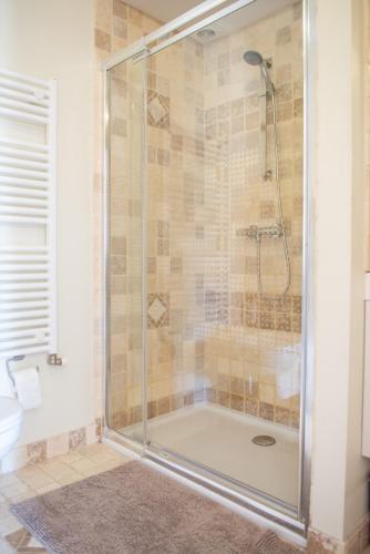 a shower with a glass door in a bathroom at B&B Fragaria in Hoogstraten