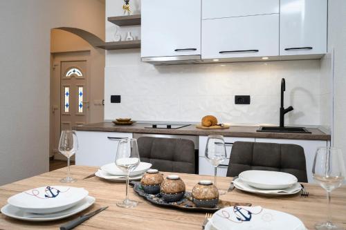 a kitchen with a table with plates and wine glasses at Villa Vista in Jelsa