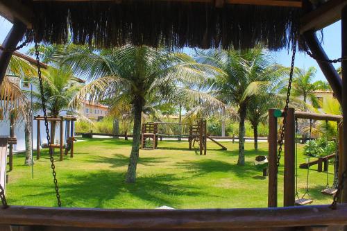 a swing yard with a playground with palm trees at OYO Pousada do Wagner, Rio das Ostras in Rio das Ostras