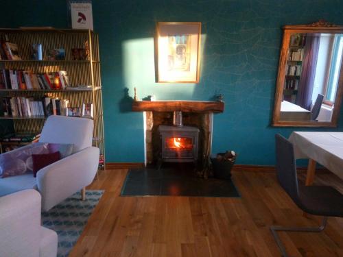 a living room with a fireplace and a table and chairs at vive les vacances in Plouguenast Langast