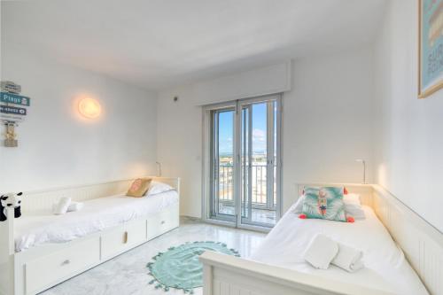1 Schlafzimmer mit 2 Betten und einem großen Fenster in der Unterkunft Première ligne - Première conciergerie in Palavas-les-Flots