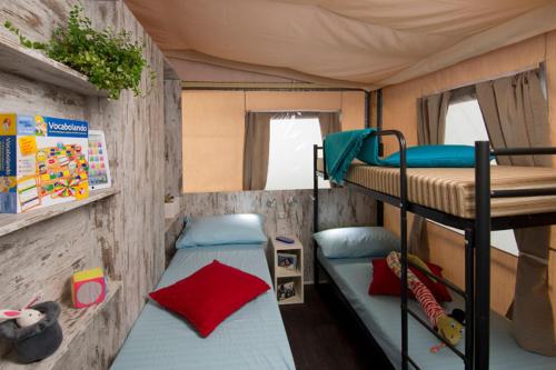 1 dormitorio con 2 literas en una cabaña en Camping Laguna Village, en Caorle