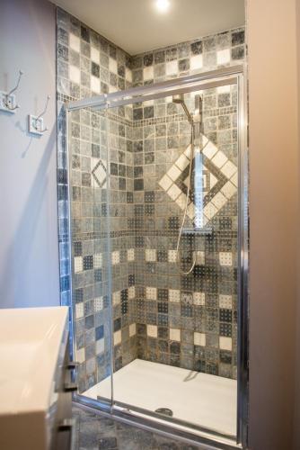 a shower with a glass door in a bathroom at B&B Fragaria in Hoogstraten