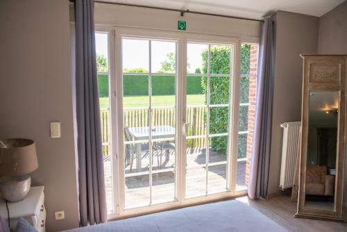 a sliding glass door leading to a deck at B&B Fragaria in Hoogstraten