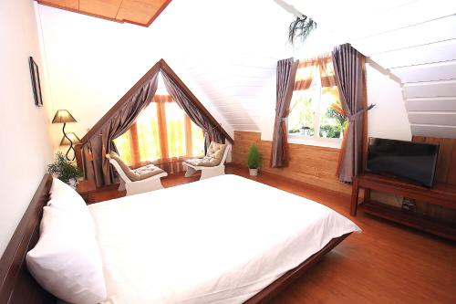 a bedroom with a bed and a flat screen tv at Dan Chi Hotel in Da Lat