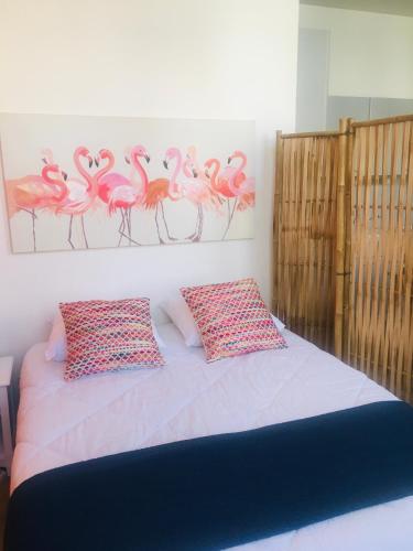 - une chambre dotée d'un lit avec des flamants roses sur le mur dans l'établissement Le Temps d une Pause Studio Centre ville, à Dieppe