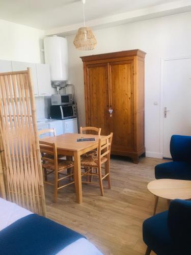 une cuisine et une salle à manger avec une table et des chaises en bois dans l'établissement Le Temps d une Pause Studio Centre ville, à Dieppe