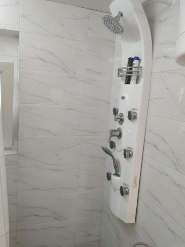 a shower in a bathroom with white marble tiles at Apartman Azzuro Vrnjačka Banja in Vrnjačka Banja