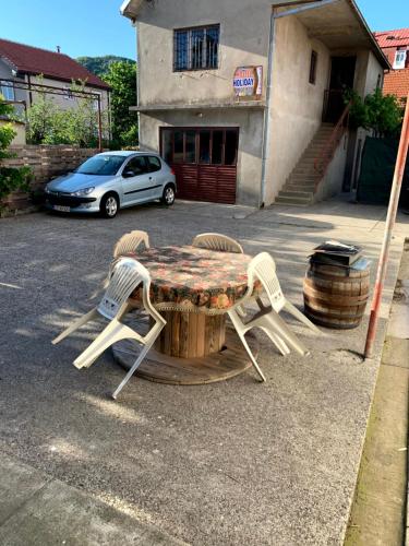 a table and two chairs and a car in a parking lot at Hostel Holiday Cetinje in Cetinje