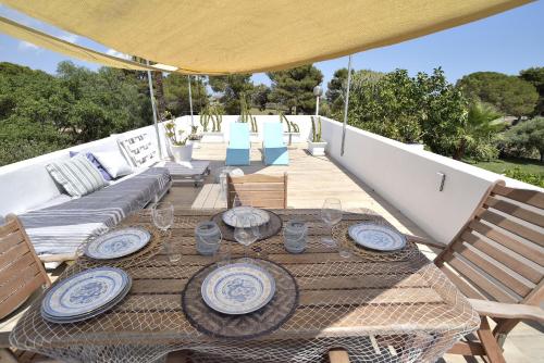 una mesa de madera con platos en el patio en Romantic House Porto Ulisse, en Santa Maria del Focallo