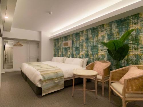 sypialnia z łóżkiem, stołem i krzesłami w obiekcie Randor Residential Hotel Fukuoka Classic w mieście Fukuoka