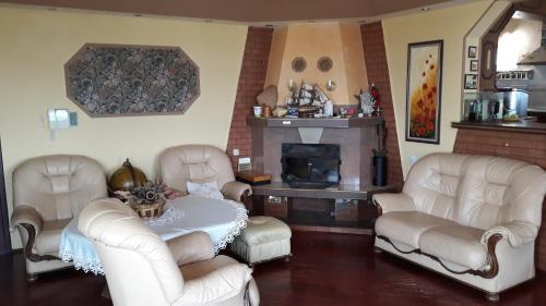 a living room with white chairs and a table and a fireplace at Vacation Home Seadream in Varna City