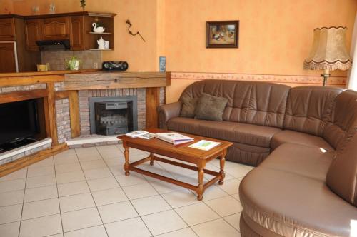 a living room with a couch and a fireplace at Gîtes de Chevémont in Plombières