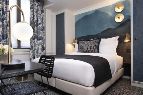 a hotel room with a bed and a table at Hôtel Gramont in Paris