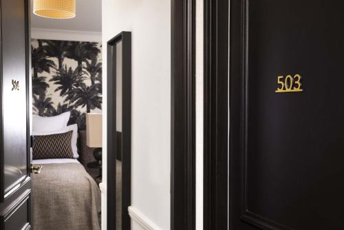 a bedroom with a bed and a clock on the door at Hôtel Gramont in Paris