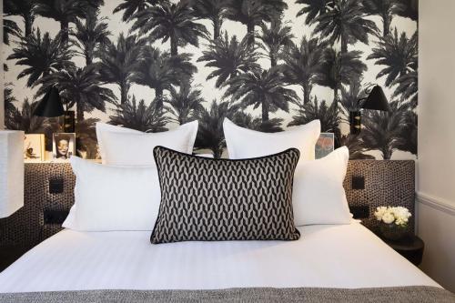 a bedroom with a bed with black and white pillows at Hôtel Gramont in Paris