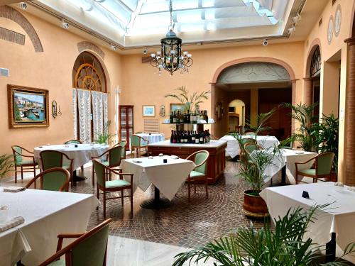 Phi Hotel Dei Medaglioni في كوريدجو: مطعم بطاولات وكراسي وثريا