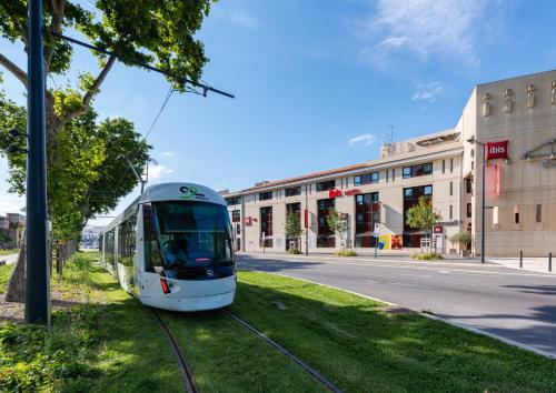 a tram on a street in front of a building at ibis Avignon Centre Pont De L'Europe in Avignon