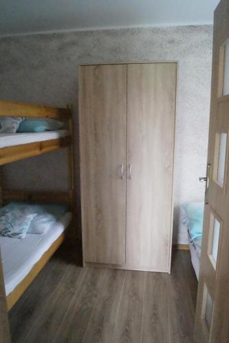 a room with two bunk beds and a cabinet at Domki u Piotrusia in Żarnowska