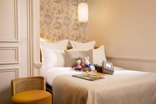 a bedroom with a bed with two stuffed animals on it at Hôtel Gramont in Paris