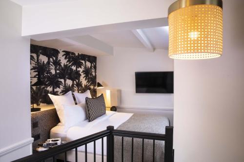 ein Hotelzimmer mit einem Bett und einem TV in der Unterkunft Hôtel Gramont in Paris