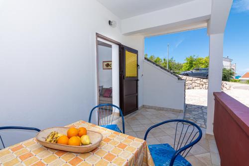 a table with a bowl of fruit on a balcony at Apartment Plemić in Pag