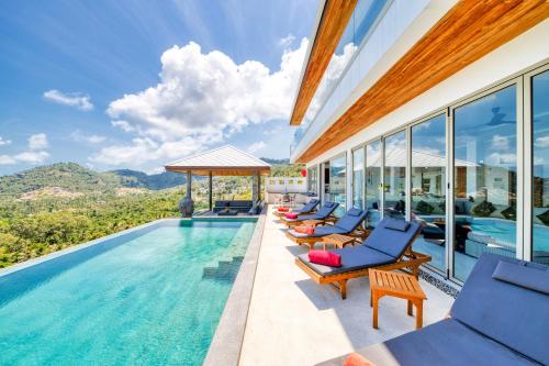 a swimming pool with lounge chairs and a pool house at Villa Jaliza - Chaweng Noi in Chaweng Noi Beach