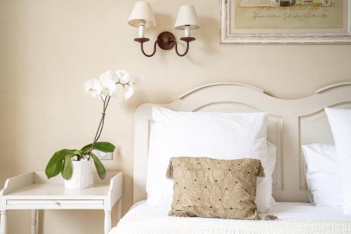 a bedroom with a white bed with a pillow and a table at Hôtel Le Pré Saint Michel in Manosque