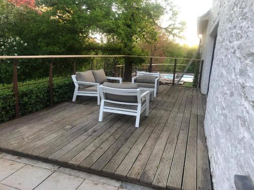 a wooden deck with chairs and a table on it at Gîte 7 personnes- Le Refuge du Saule in Burdinne