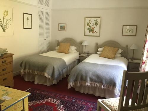 Llanwrtyd WellsにあるKilsby Houseのベッドルーム1室(ベッド2台、テーブル付)