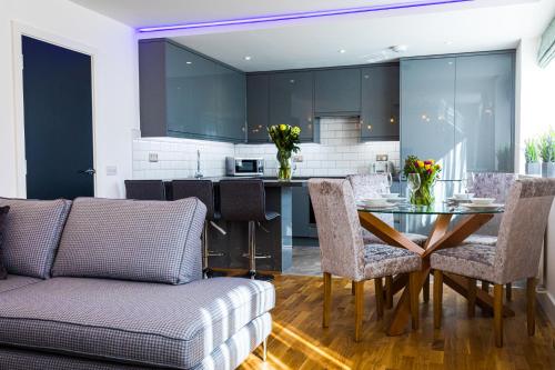 a kitchen and living room with a table and chairs at Broadstairs Apartments with luxurious 4-person communal hot tub - sleeps up to 20 people in Broadstairs