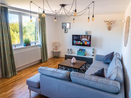 a living room with a blue couch and a table at Broadstairs Apartments with luxurious 4-person communal hot tub - sleeps up to 20 people in Broadstairs