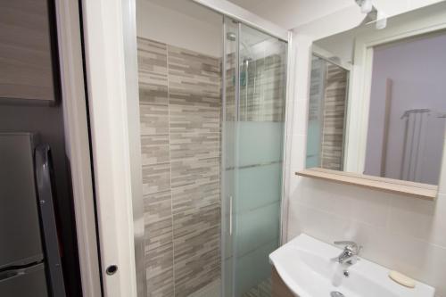 ein Bad mit einem Waschbecken und einer Glasdusche in der Unterkunft Appartamento a 3 passi dal mare in Varraze