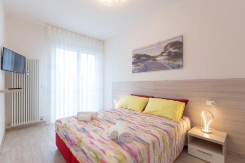 ein Schlafzimmer mit einem Bett mit einer farbenfrohen Tagesdecke in der Unterkunft Enjoy, Bologna by Short Holidays in Bologna