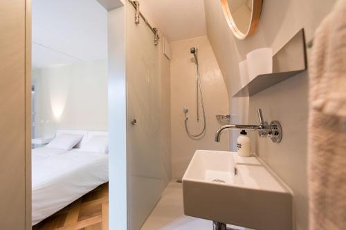 a bathroom with a sink and a bed at B&B The B in Bern