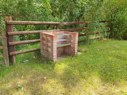 a brick fireplace in a field next to a fence at Puddleduck Valley in Holsworthy