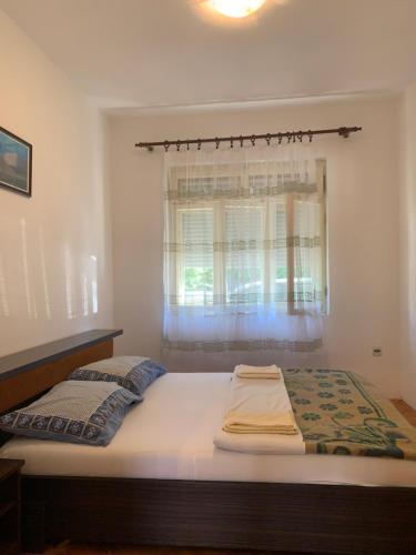 a large bed in a room with a window at Hostel Holiday Cetinje in Cetinje