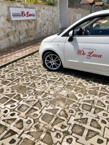 a white car parked on a stone road at Residenza De Luca Apartment in Tropea
