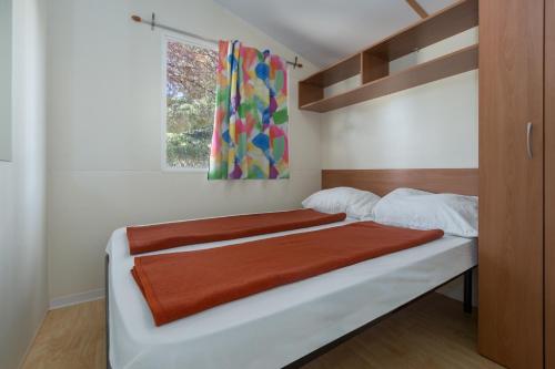 Un pat sau paturi într-o cameră la Camping Adria Mobile Homes in Brioni Sunny Camping