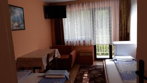 ein kleines Zimmer mit einem Tisch und einem Fenster in der Unterkunft Guest House Rusalka in Šipkovo
