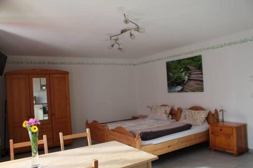 - une chambre avec un lit et une table en bois dans l'établissement Appartment am Trätzhof, à Fulde